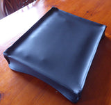 A black vinyl dust cover for Korg Monologue or Drumlogue synthesizers, displayed on a wooden surface.