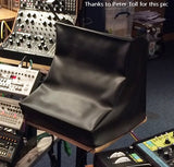 A black Moog dust cover for a synthesizer rack, displayed in front of various Moog music equipment.